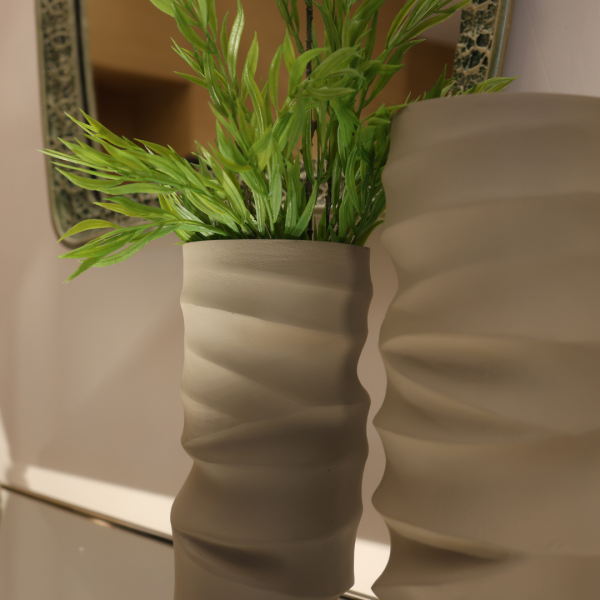 Two decorative vases with plants on a wooden surface