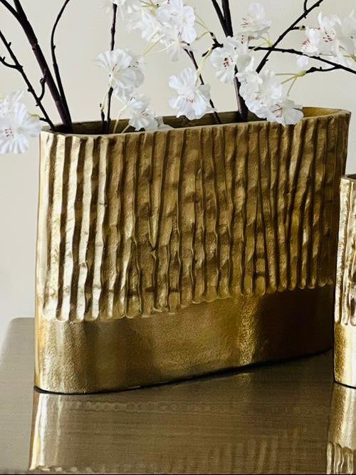 gold textured vases with white floral branches on a neutral background