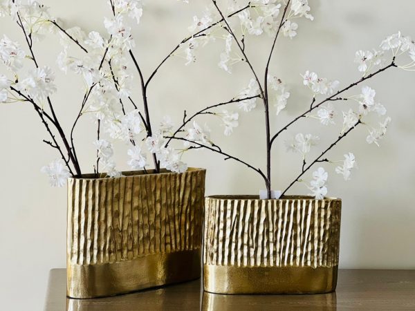 gold textured vases with white floral branches on a neutral background